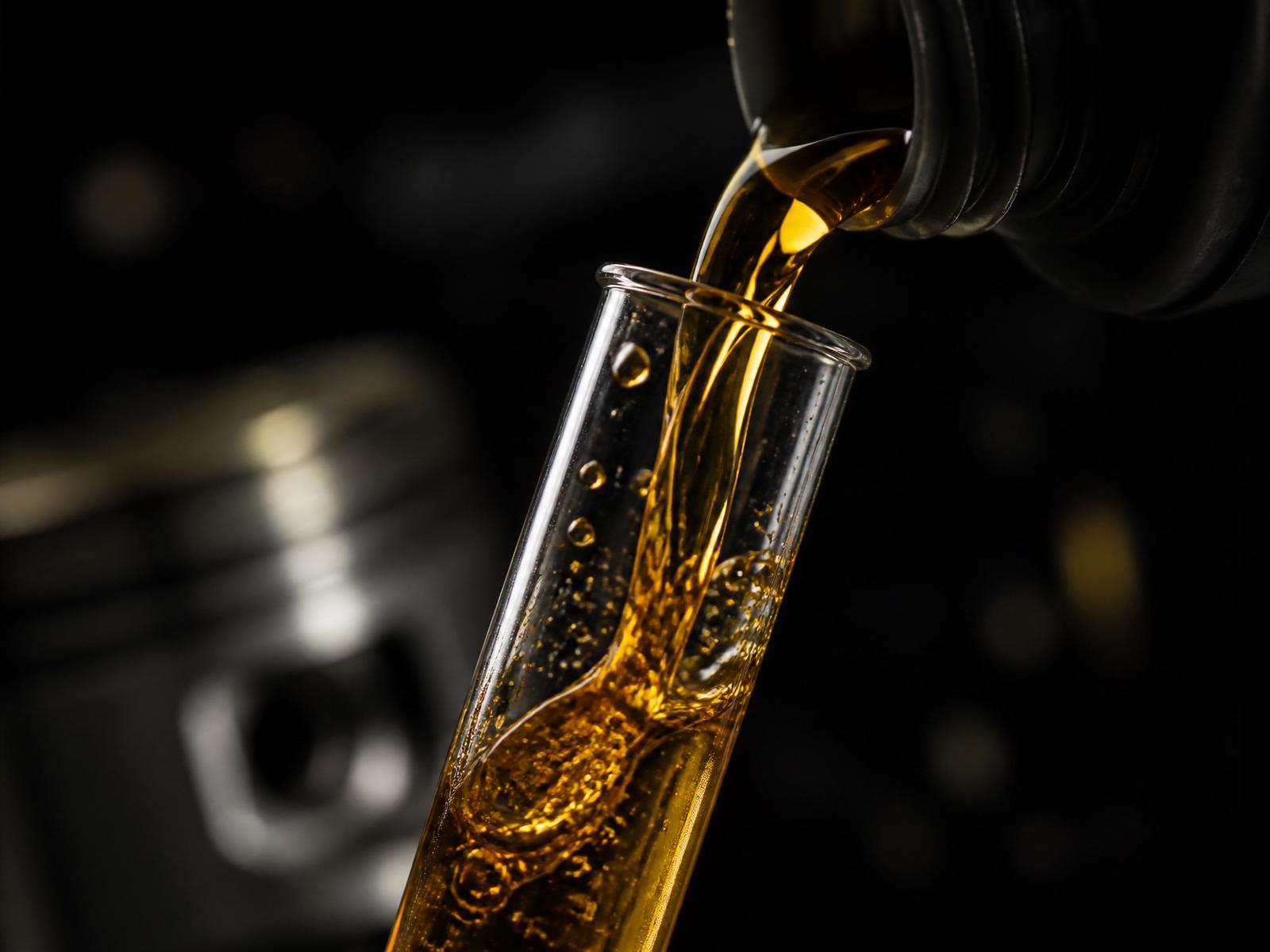 Motorový olej stéká do laboratorní zkumavky